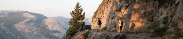 Photo of hikers on an upper section of the trail that straddles a slight break in the cliff